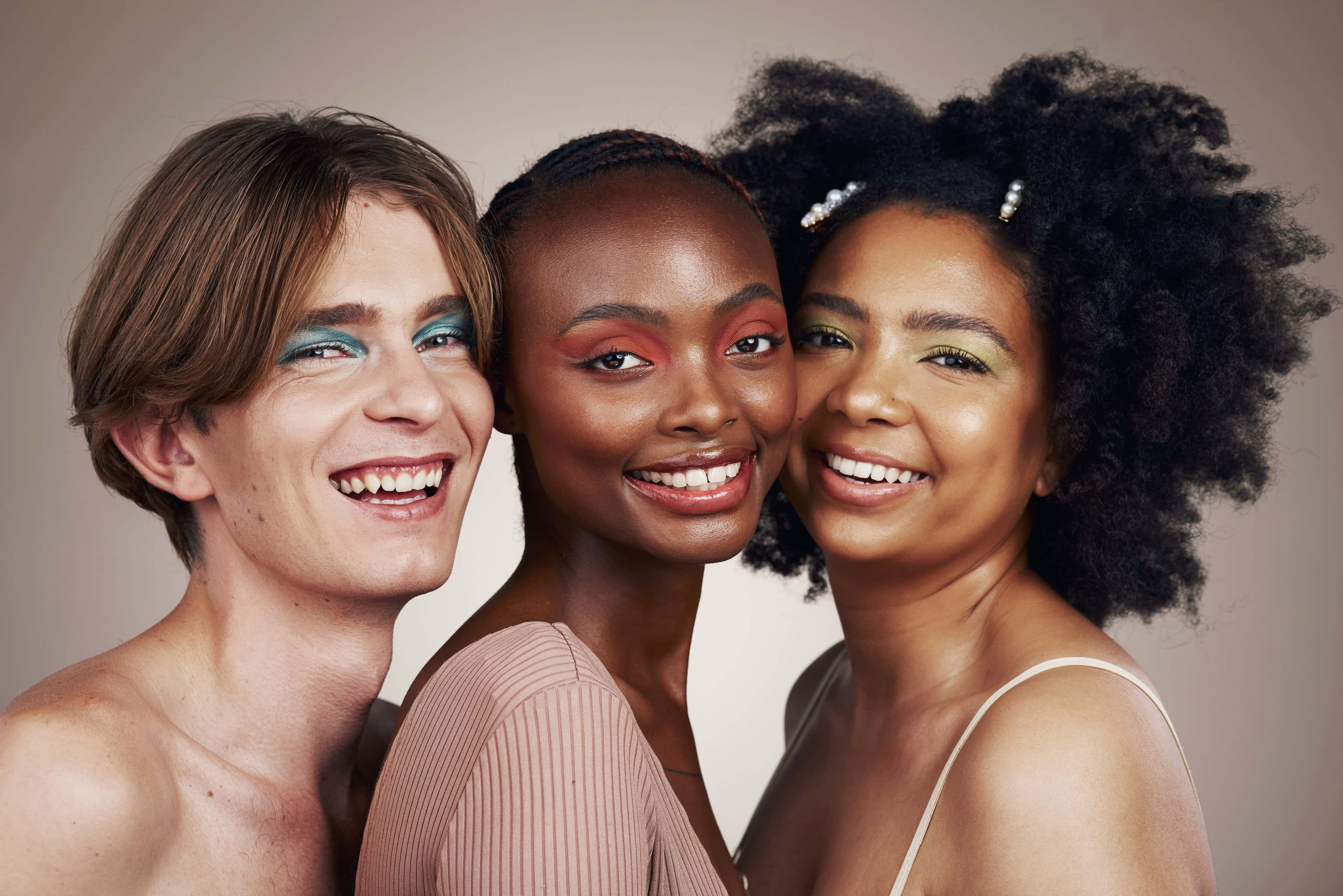 Portrait, diversity and people with makeup, smile and dermatology isolated on studio background. Face, man or women with cosmetics, multiracial or self care with inclusion, group with beauty or shine